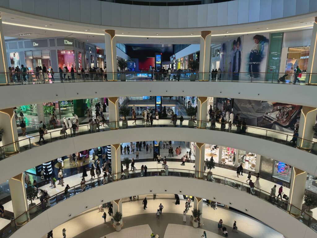 Wide-angle view of shoppers in the luxurious multi-level interior of Dubai Mall, the heart of modern retail.